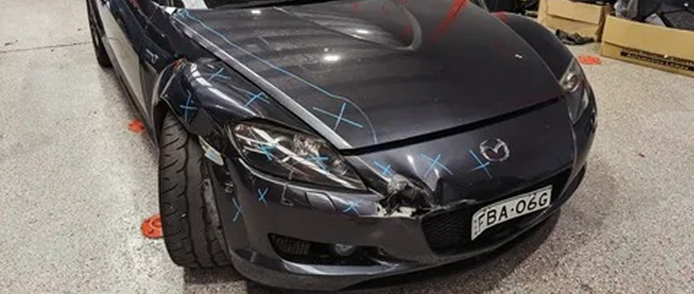 Mazda with front-end collision damage before smash repairs